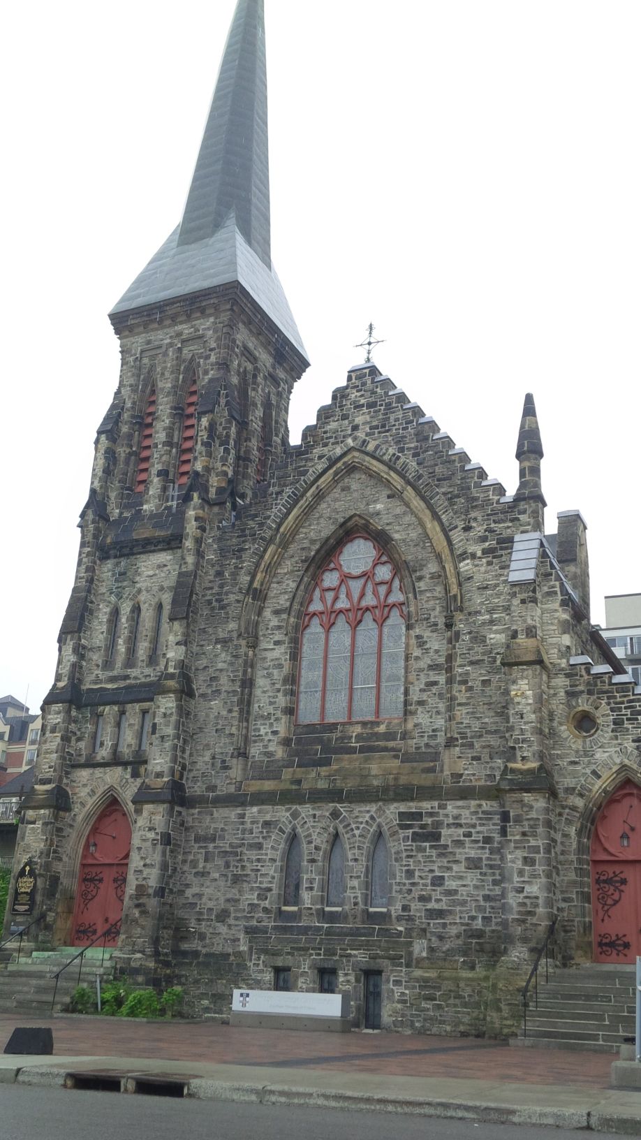 Exterior view of a Middle Pointed style of English Gothic stone church and bell tower, built in 1870.